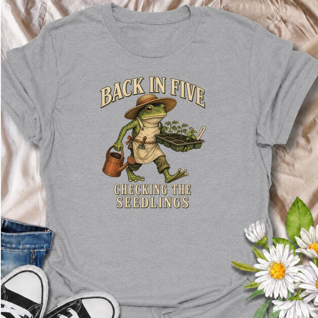 Funny gardening T-shirt for plant lovers who are always disappearing to check seedlings, water pots or inspect the garden. Features a vintage frog gardener illustration and playful “Back in Five, Checking the Seedlings” design for gardeners, growers and houseplant fans.