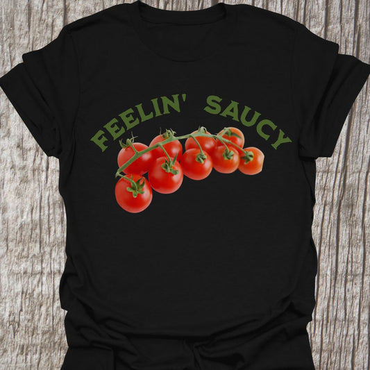 Feelin' Saucy Text written in an arch over image of tomatoes on the vine on a black t-shirt