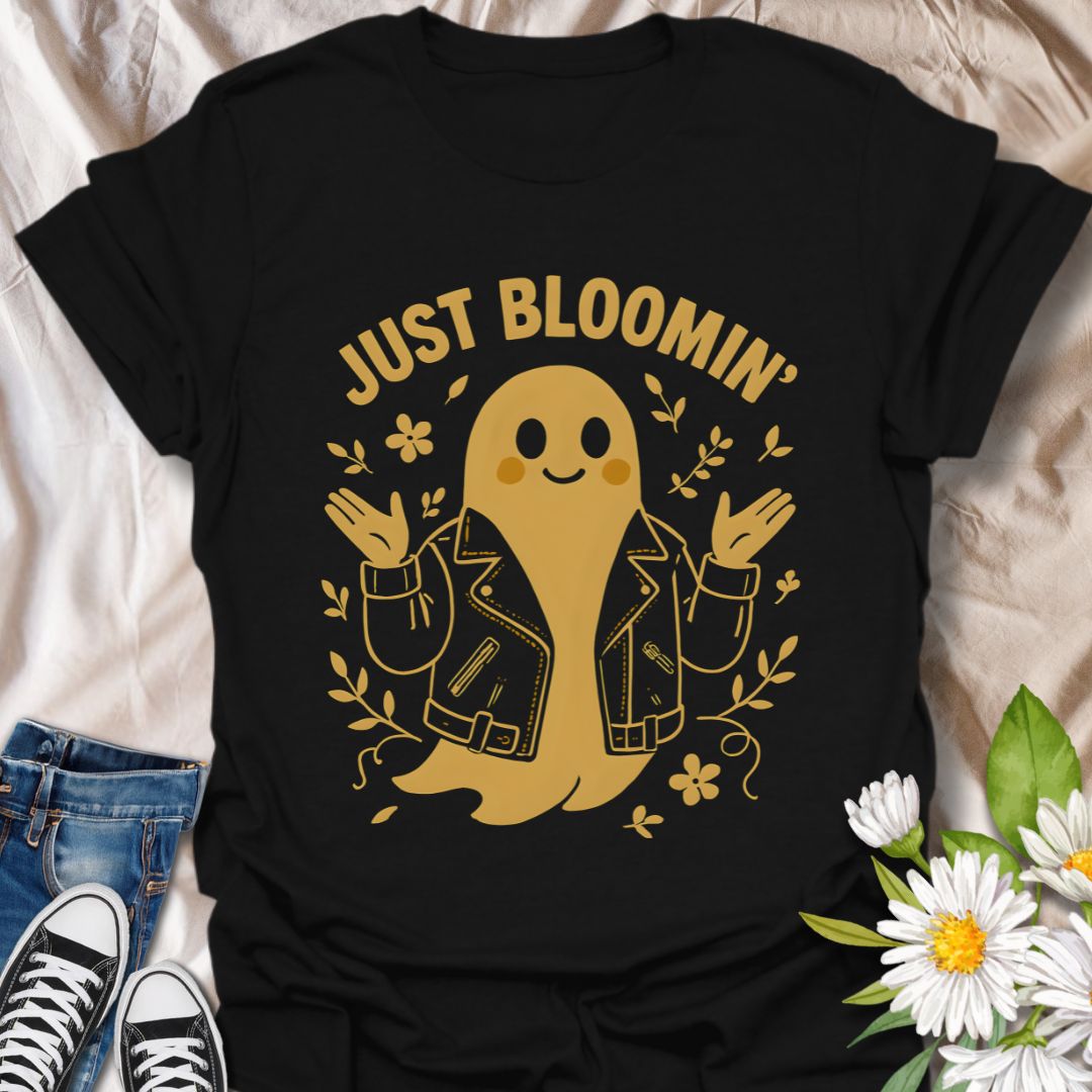 Cute ghost wearing a leather jacket surrounded by blooming flowers with the phrase "Just Bloomin'." A playful and trendy floral ghost graphic perfect for spooky season lovers, goth garden fans, and alternative aesthetic apparel.
