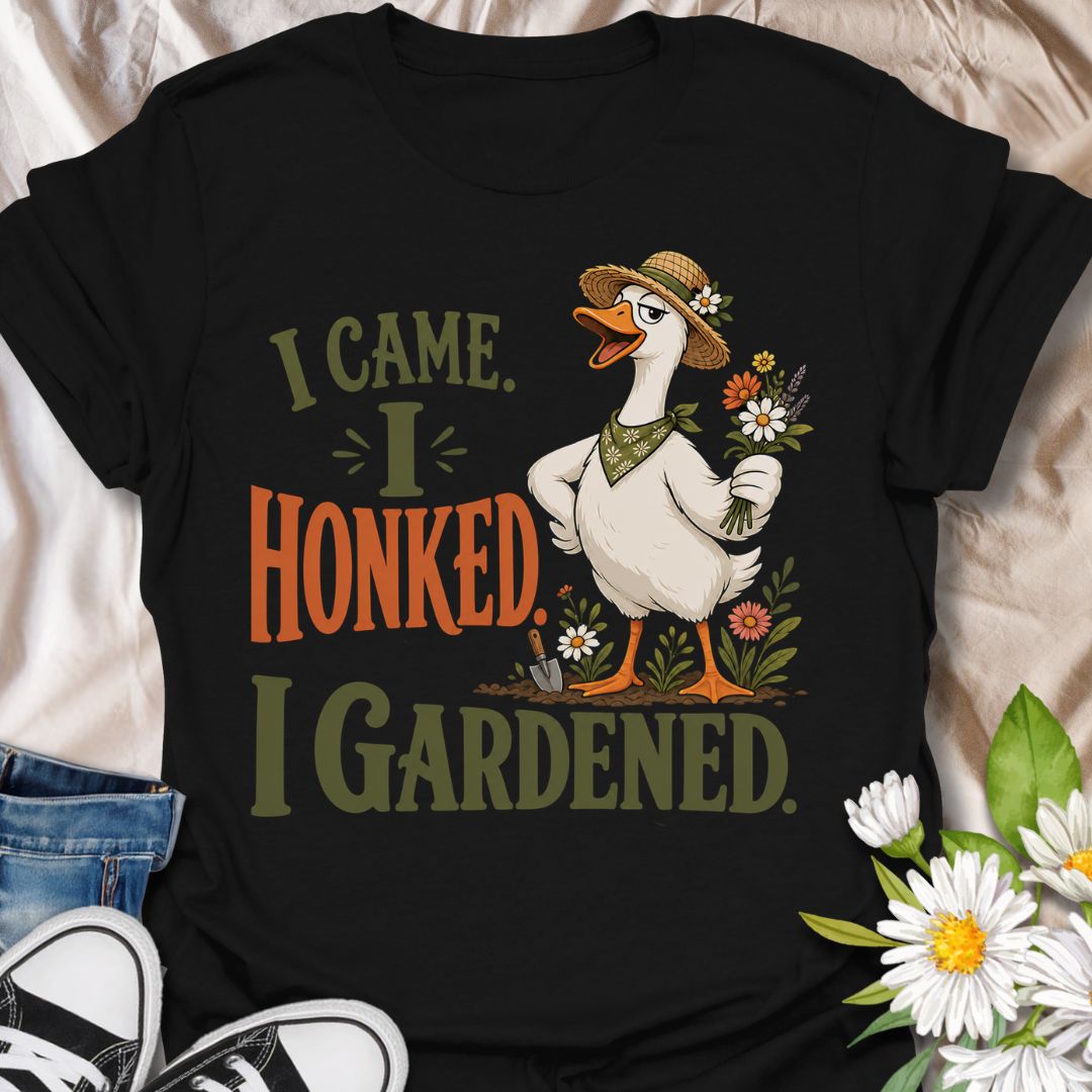 This I Came I Honked I Gardened t-shirt is made for gardeners who like their plant humor with a little chaotic goose energy. Featuring a confident garden goose in a straw hat holding flowers, surrounded by blooms, a trowel, soil, and bold vintage-style lettering, this design has a funny cottagecore garden feel. Perfect for gardeners, plant lovers, flower fans, goose lovers, backyard growers, and anyone who enjoys a playful botanical design with attitude.