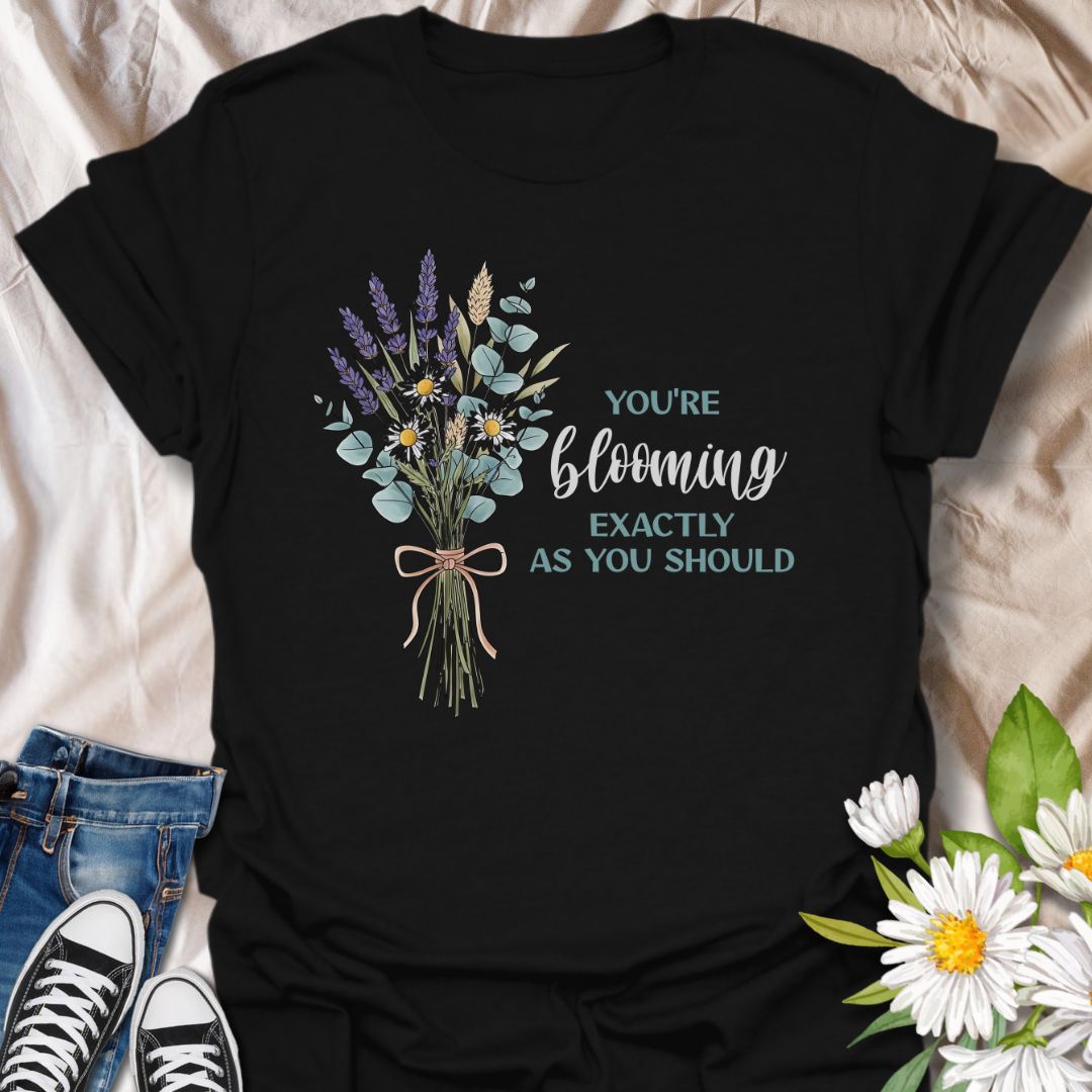Celebrate growth and self-love with this elegant floral quote t-shirt. Featuring a beautifully illustrated bouquet and the inspiring words "You're blooming exactly as you should", this black tee is perfect for anyone on a journey of personal growth. A thoughtful gift for plant lovers, teachers, mental health advocates, or anyone who appreciates uplifting messages in nature-inspired fashion.