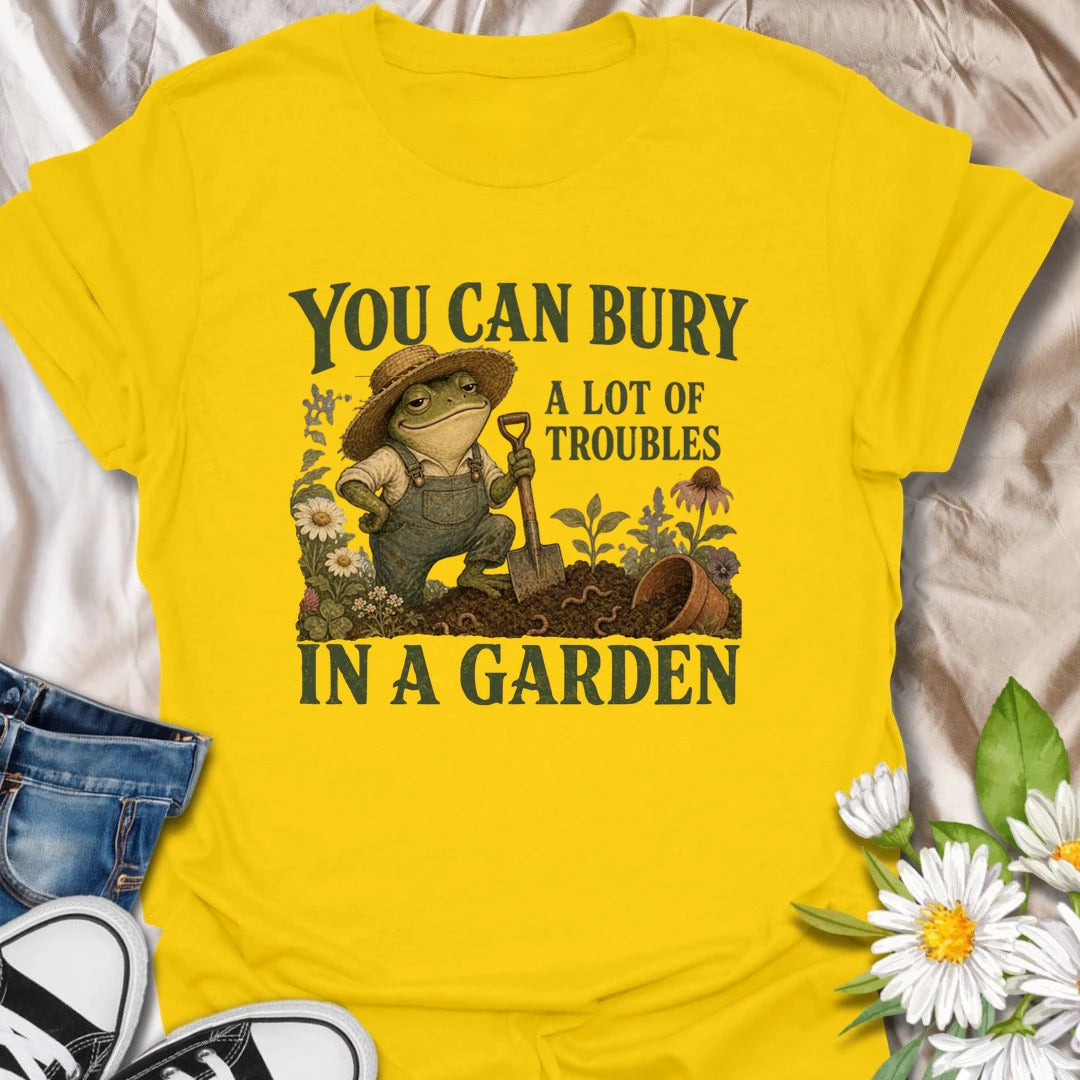 Funny gardening t-shirt with a charming frog and the classic saying about burying troubles in a garden.
Features vintage-style garden art with flowers, rich soil, and a playful frog gardener holding a shovel.
A great gift for gardeners, frog lovers, flower lovers, and anyone who finds peace and humor in the garden.