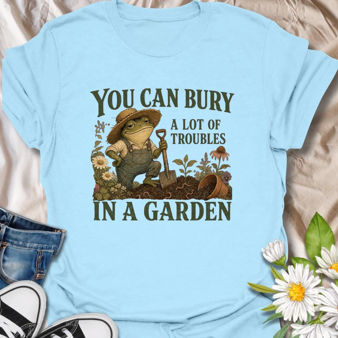 Funny gardening t-shirt with a charming frog and the classic saying about burying troubles in a garden.
Features vintage-style garden art with flowers, rich soil, and a playful frog gardener holding a shovel.
A great gift for gardeners, frog lovers, flower lovers, and anyone who finds peace and humor in the garden.