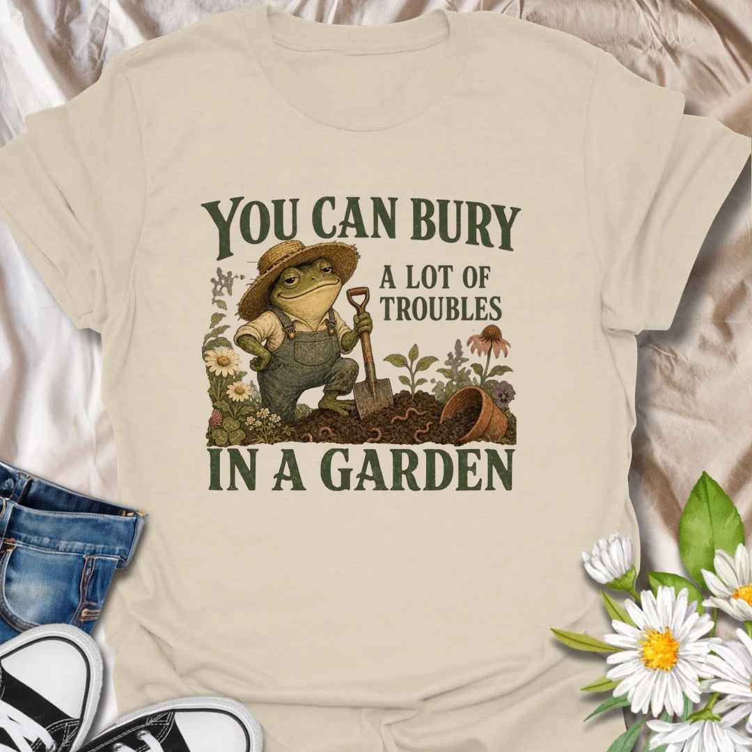 Funny gardening t-shirt with a charming frog and the classic saying about burying troubles in a garden.
Features vintage-style garden art with flowers, rich soil, and a playful frog gardener holding a shovel.
A great gift for gardeners, frog lovers, flower lovers, and anyone who finds peace and humor in the garden.
