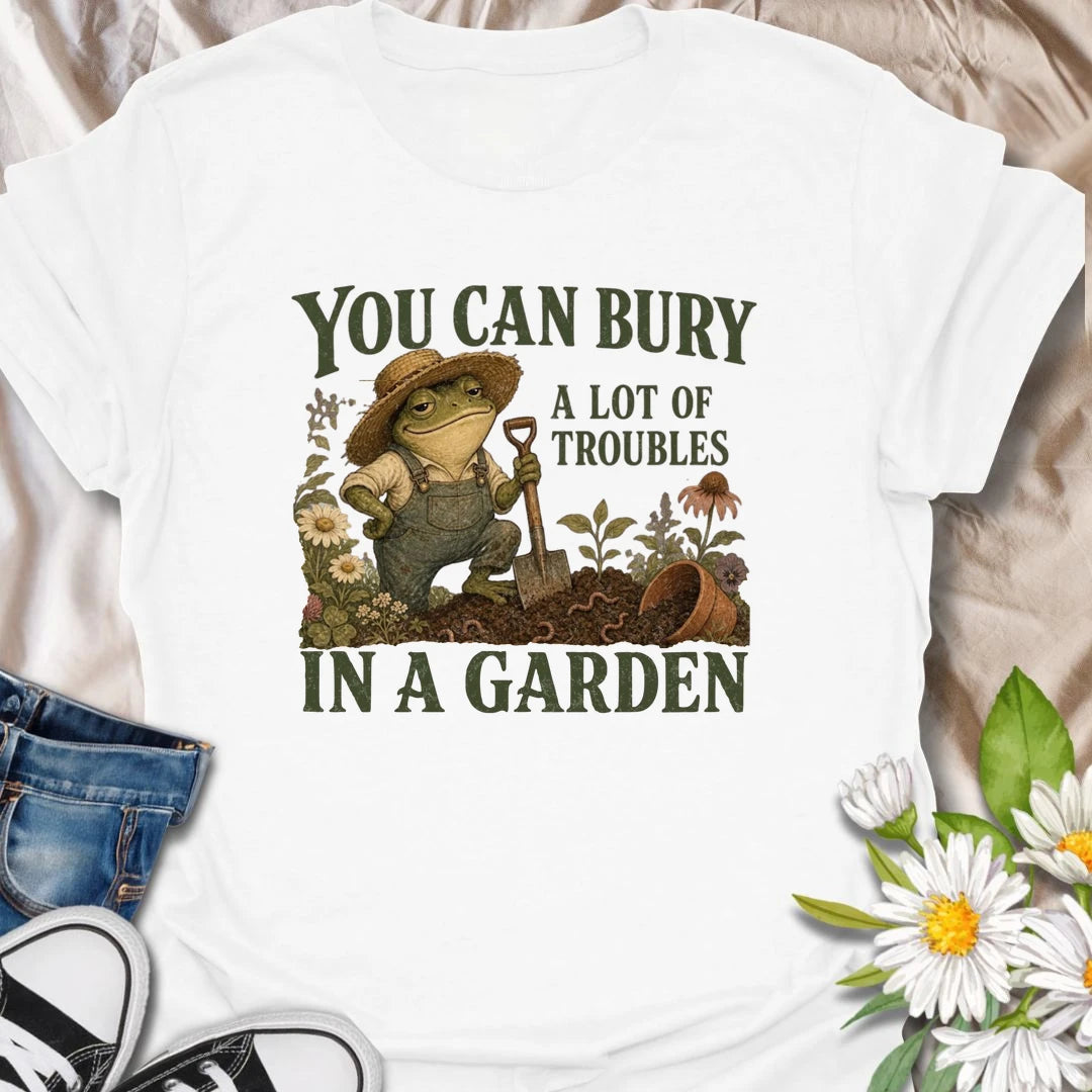 Funny gardening t-shirt with a charming frog and the classic saying about burying troubles in a garden.
Features vintage-style garden art with flowers, rich soil, and a playful frog gardener holding a shovel.
A great gift for gardeners, frog lovers, flower lovers, and anyone who finds peace and humor in the garden.