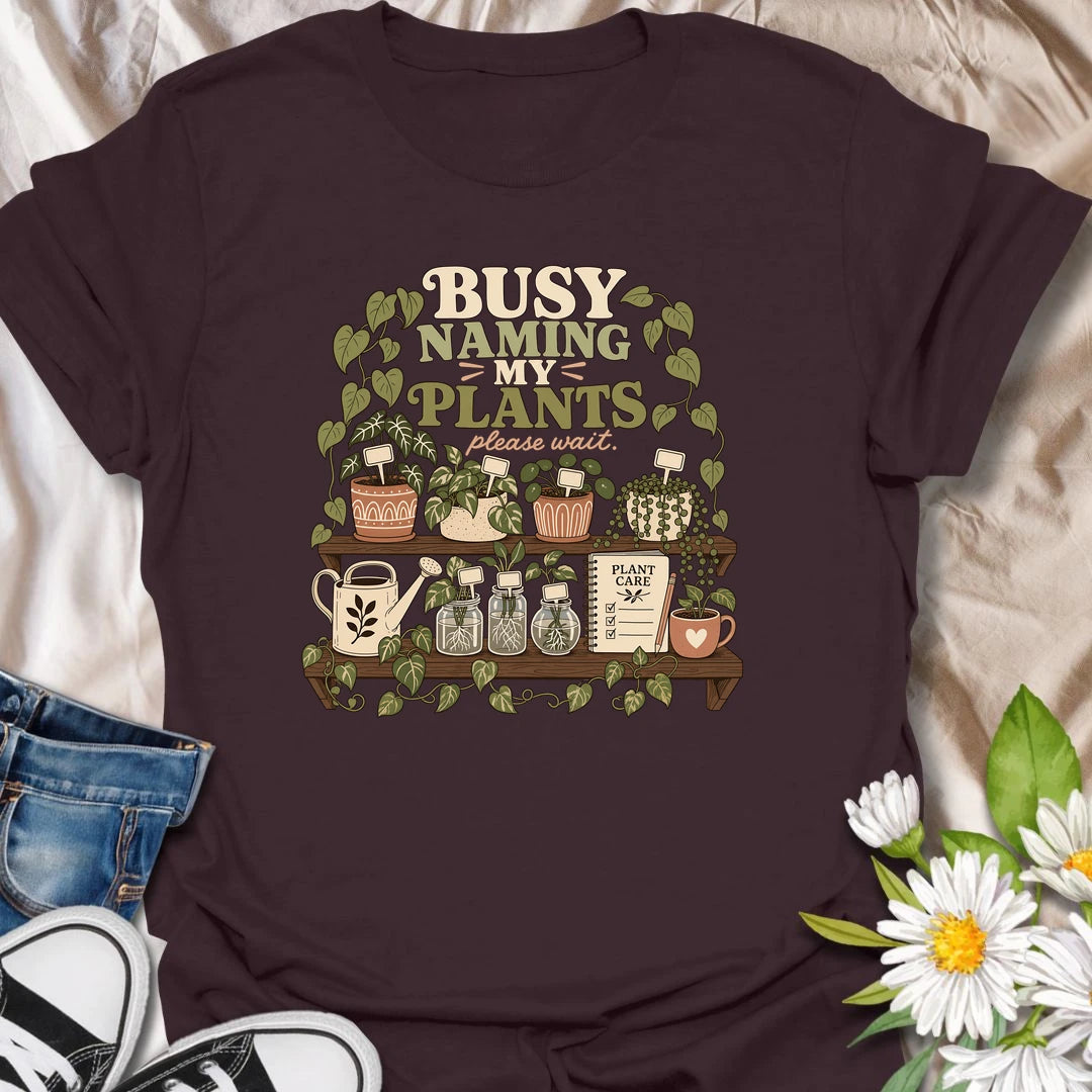 A funny plant lover T-shirt for anyone who treats every houseplant like part of the family. The detailed design features potted plants, propagation jars, gardening tools, and a plant care notebook. A charming gift for plant moms, houseplant collectors, and indoor gardening enthusiasts.