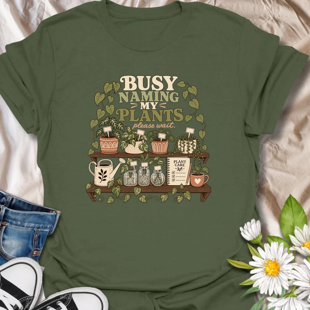 A funny plant lover T-shirt for anyone who treats every houseplant like part of the family. The detailed design features potted plants, propagation jars, gardening tools, and a plant care notebook. A charming gift for plant moms, houseplant collectors, and indoor gardening enthusiasts.