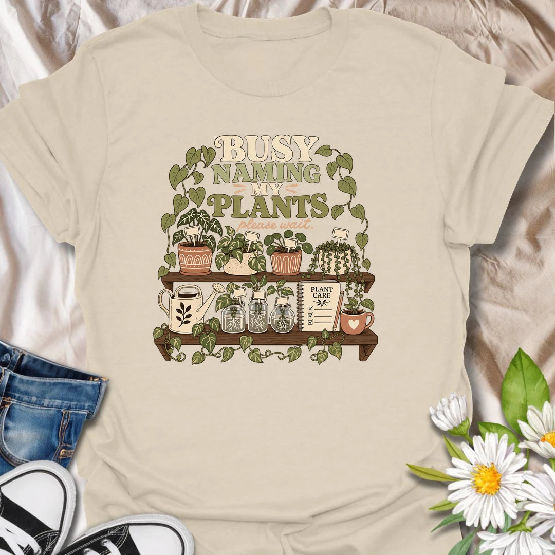 A funny plant lover T-shirt for anyone who treats every houseplant like part of the family. The detailed design features potted plants, propagation jars, gardening tools, and a plant care notebook. A charming gift for plant moms, houseplant collectors, and indoor gardening enthusiasts.