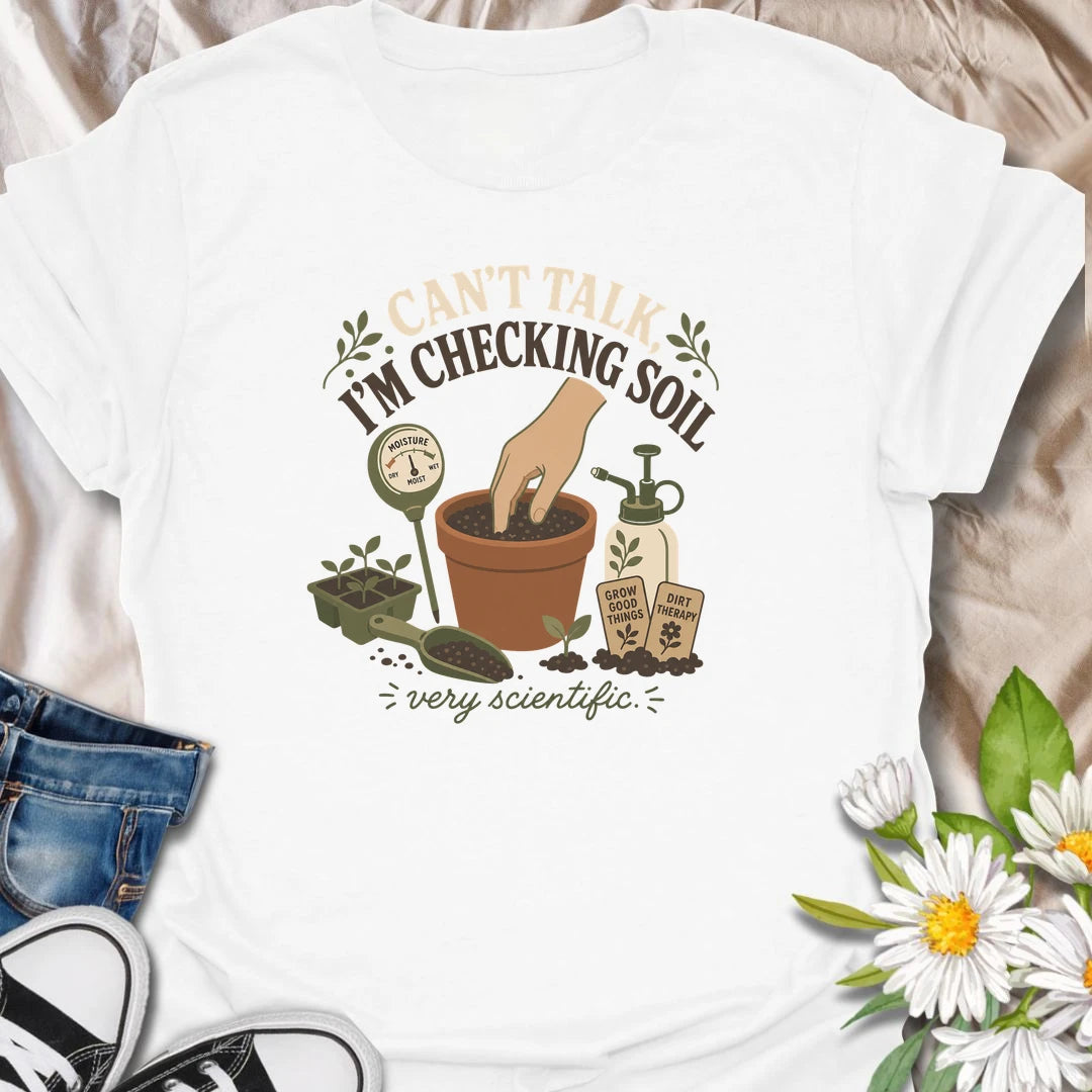 A humorous gardening T-shirt for plant lovers who take soil checks very seriously. The design features a terracotta pot, moisture meter, seedlings, mister, and gardening accessories. A fun gift for houseplant owners, gardeners, and anyone regularly caught testing their potting soil.