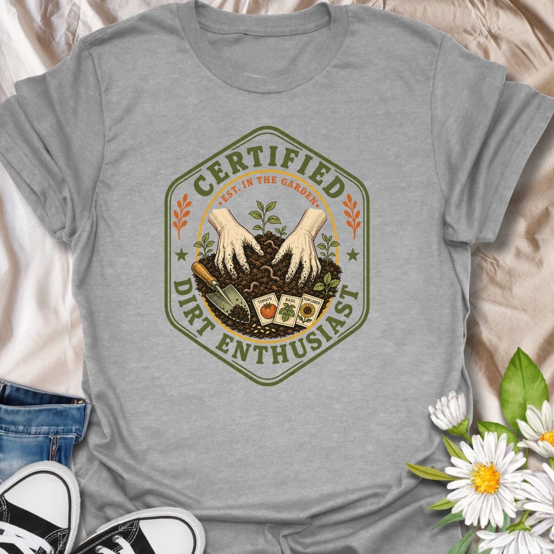 This Certified Dirt Enthusiast t-shirt is made for gardeners who are happiest with their hands in the soil and seedlings ready to grow. Featuring a vintage badge-style design with gloved hands, rich garden dirt, seed packets, tools, and fresh sprouts, this tee has a classic gardening-club feel with plenty of earthy personality. Perfect for gardeners, plant lovers, backyard growers, vegetable gardeners, flower fans, and anyone who proudly loves dirt, seeds, and garden time.