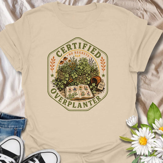 This Certified Overplanter t-shirt is made for gardeners who know there is always room for just one more seedling, even when the garden is already overflowing. Featuring a vintage badge-style design with crowded garden beds, seed packets, an open seed catalog, a sold out pot, and the phrase No Regrets, this tee has a funny plant-lover feel with classic garden-club charm. Perfect for gardeners, plant lovers, backyard growers, flower fans, vegetable gardeners, and anyone who proudly overplants every season.