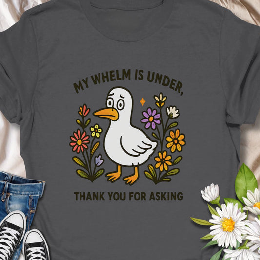 Relatable and funny, this "My Whelm Is Under, thank you for asking" t-shirt features a quirky duck and floral design. A lighthearted, everyday tee that speaks to anyone juggling a lot and hiding it behind a brave face. The cheerful cartoon duck and hand-drawn florals deliver a gentle, ironic message.   Wear it on slow mornings, busy commutes, or casual meetups when you want an honest smile without a long conversation. 