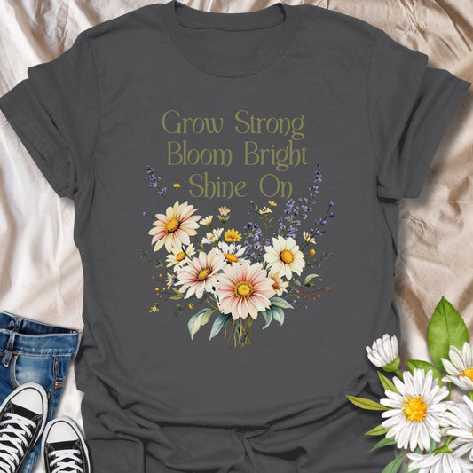 Embrace positivity and growth with this beautifully designed floral t-shirt featuring the empowering phrase "Grow Strong, Bloom Bright, Shine On". This tee has a vibrant bouquet of daisies and wildflowers, this inspirational tee is perfect for nature lovers, garden enthusiasts, teachers, or anyone who believes in blooming through life’s seasons. A thoughtful gift for those who radiate light and strength.