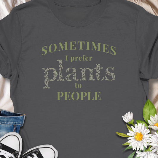 This tee speaks to the plant-lover who finds calm in soil, leaves, and slow-growing routines. The muted, nature-toned print reads “Sometimes I prefer plants to people,” a little wry and wholly relatable. Wear it while tending a crowded windowsill, carrying new finds home from the nursery, or lounging with a book as your succulents soak up afternoon light. 