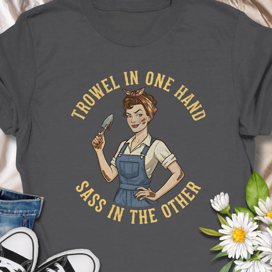 A bold, vintage-inspired gardening t-shirt featuring the phrase “Trowel in One Hand, Sass in the Other.” Perfect for confident gardeners, plant moms, and anyone who loves humor, dirt, and a little attitude in the garden.