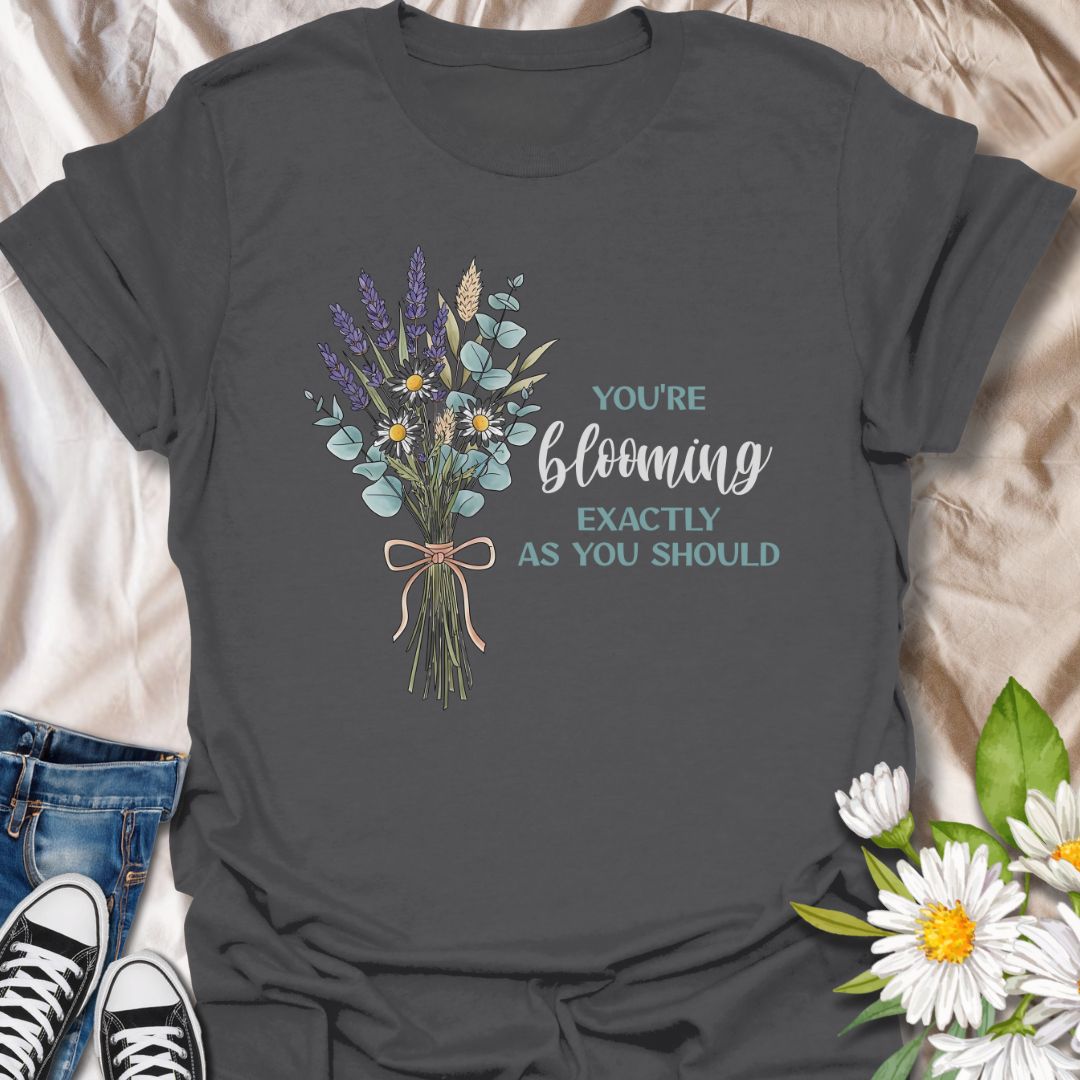 Celebrate growth and self-love with this elegant floral quote t-shirt. Featuring a beautifully illustrated bouquet and the inspiring words "You're blooming exactly as you should", this tee is perfect for anyone on a journey of personal growth. A thoughtful gift for plant lovers, teachers, mental health advocates, or anyone who appreciates uplifting messages in nature-inspired fashion.