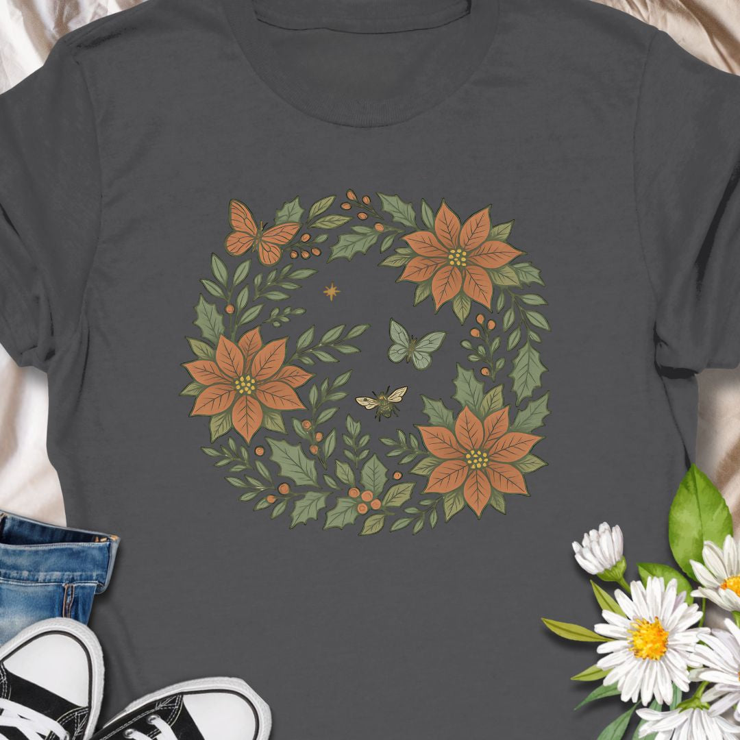Festive botanical tee featuring a Christmas wreath with poinsettias, bees, and butterflies. Perfect holiday wear for plant lovers.