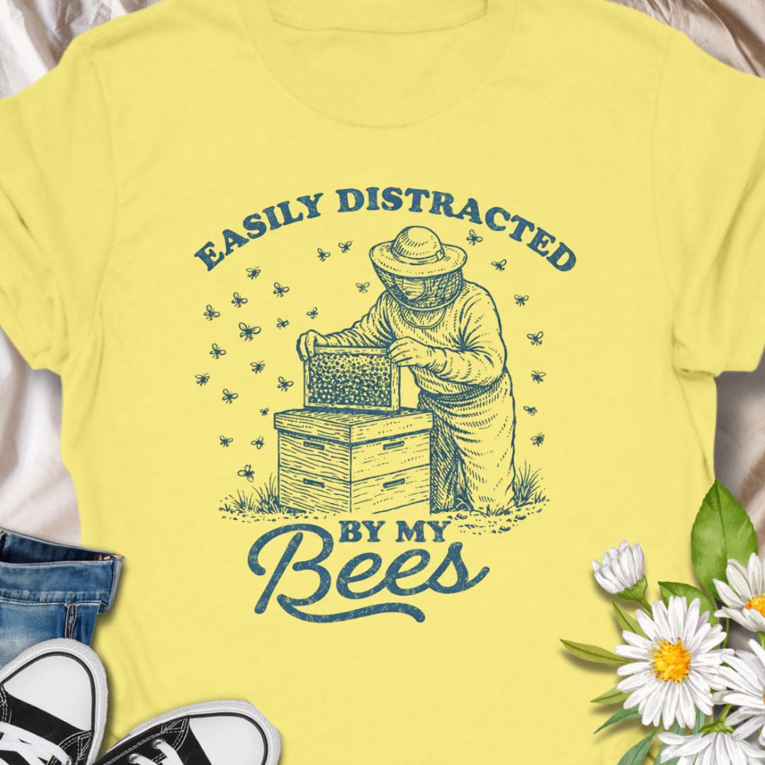 Show off your hive obsession with this “Easily Distracted By My Bees” t-shirt, featuring a vintage-style beekeeper and buzzing bees. Perfect gift for apiarists, backyard beekeepers, and bee lovers who’d rather be checking their hives than anything else.