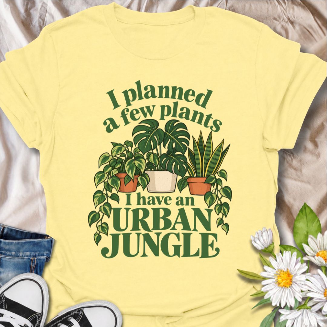 A funny plant T-shirt for anyone who started with a few houseplants and somehow ended up living in an indoor jungle. The phrase “I Planned a Few Plants. I Have an Urban Jungle.” captures the familiar reality of plant collecting with light, relatable humor. Featuring monstera, pothos, and snake plants, this design is perfect for plant parents, houseplant collectors, and indoor gardeners. It makes a great gift for anyone whose shelves, windowsills, and corners have slowly disappeared behind greenery. Perfect 