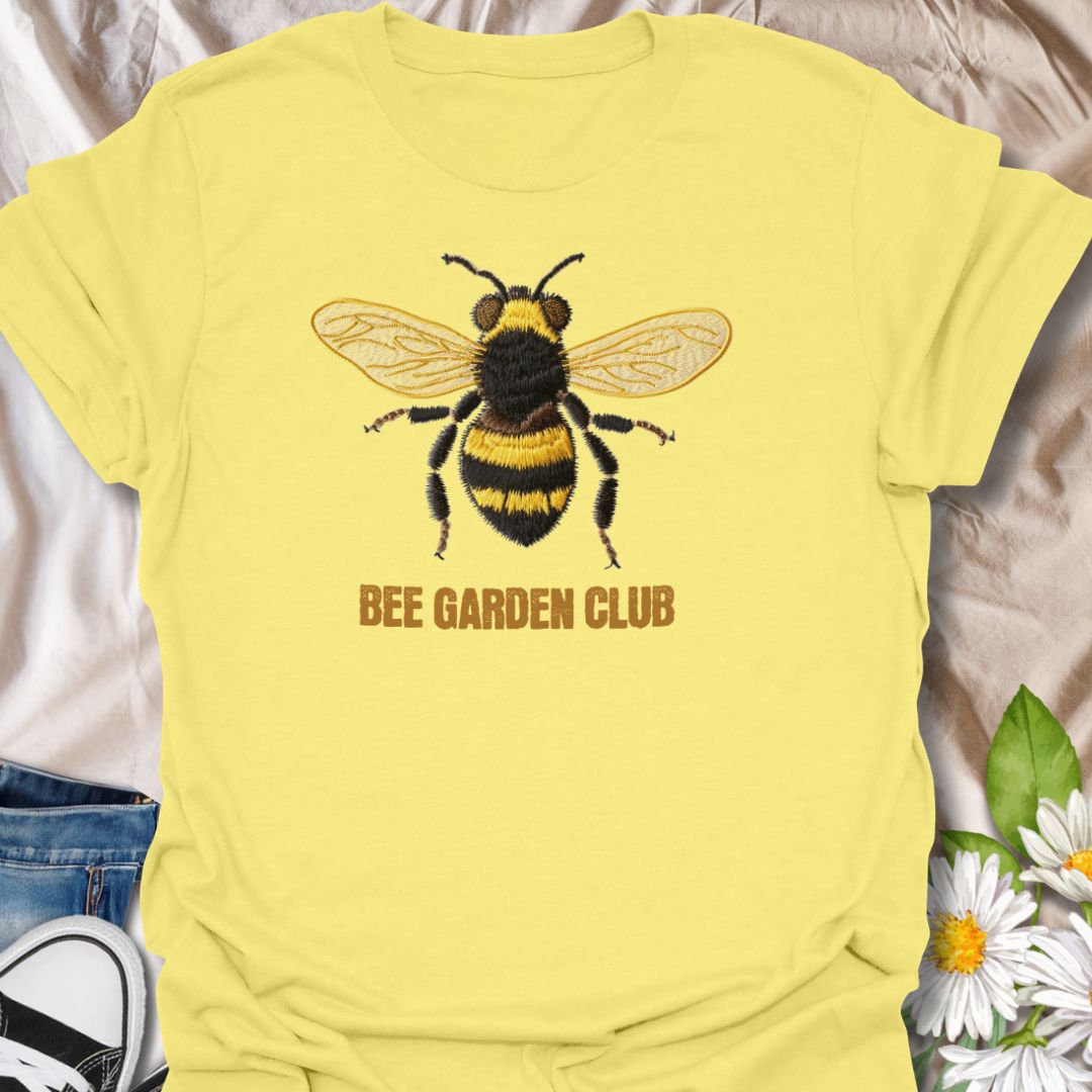 This Bee Garden Club t-shirt is made for gardeners, pollinator lovers, and nature fans who want a simple bee design with a refined botanical feel. Featuring a detailed faux-embroidered bee with golden wings, fuzzy black and yellow stripes, and clean Bee Garden Club lettering, this design has a classic garden-club look that is easy to wear. Perfect for bee lovers, gardeners, wildflower fans, pollinator supporters, nature lovers, and anyone who wants to celebrate the garden’s hardest little workers.