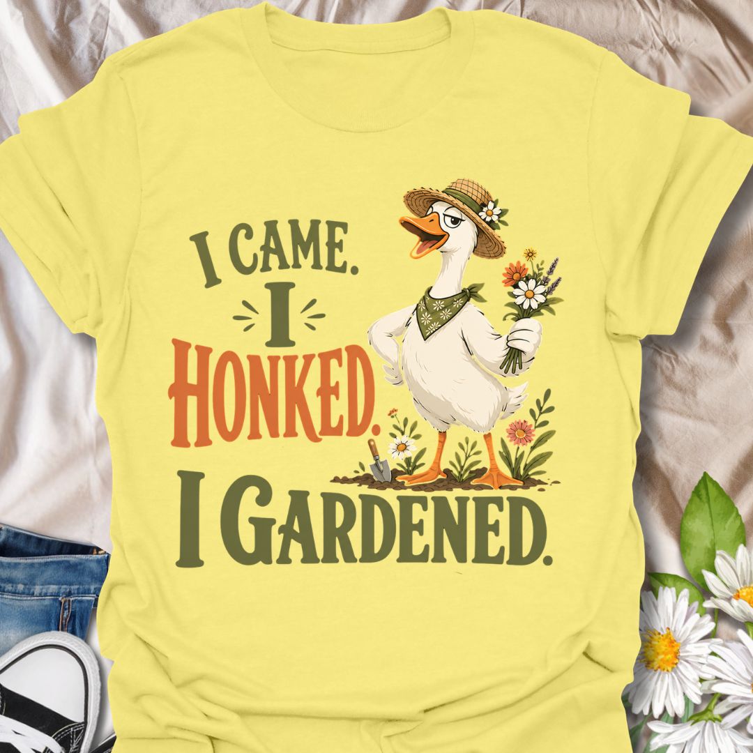 This I Came I Honked I Gardened t-shirt is made for gardeners who like their plant humor with a little chaotic goose energy. Featuring a confident garden goose in a straw hat holding flowers, surrounded by blooms, a trowel, soil, and bold vintage-style lettering, this design has a funny cottagecore garden feel. Perfect for gardeners, plant lovers, flower fans, goose lovers, backyard growers, and anyone who enjoys a playful botanical design with attitude.