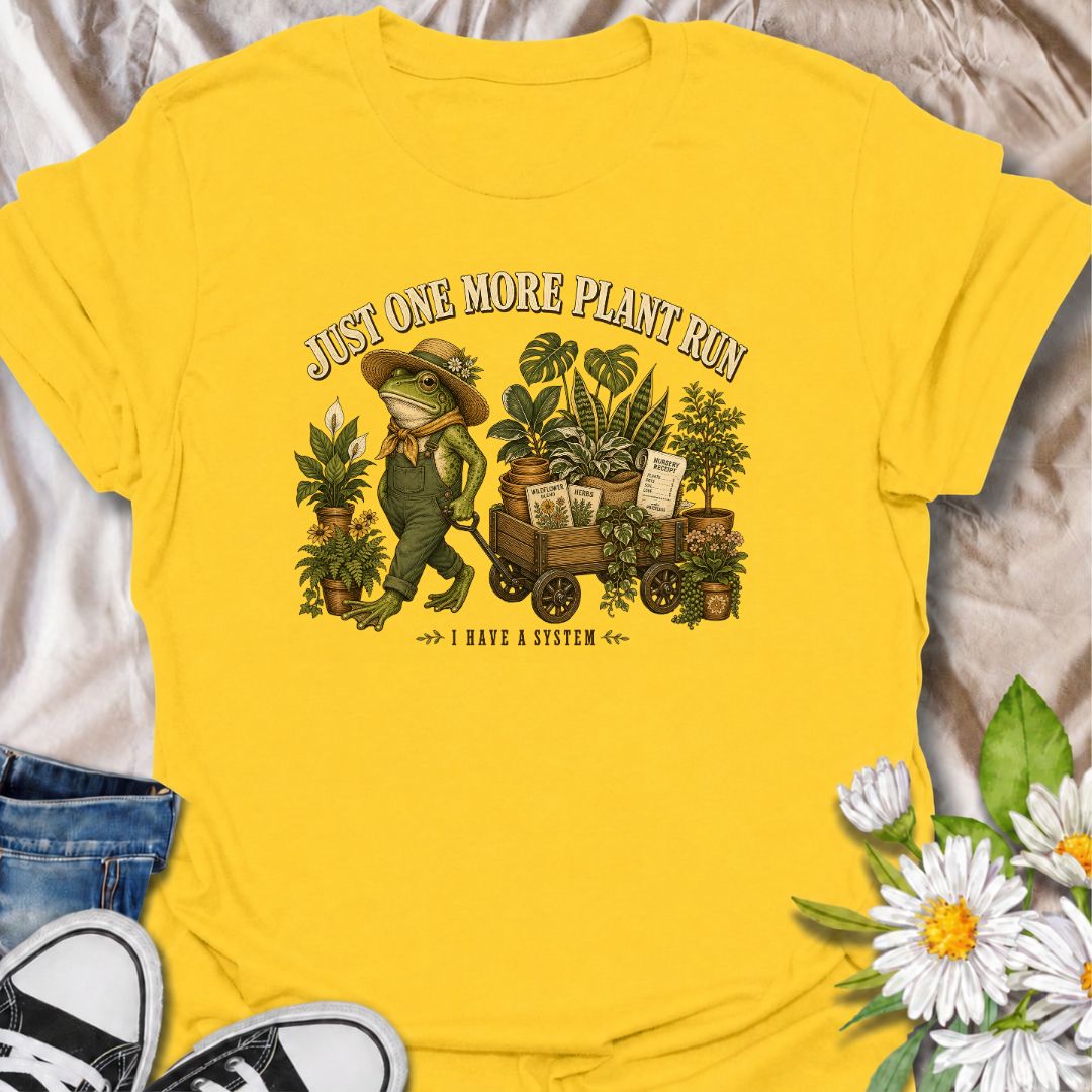 A funny plant-shopping T-shirt featuring a stylish frog and a wagon full of nursery finds. Made for plant lovers who can never buy just one more.