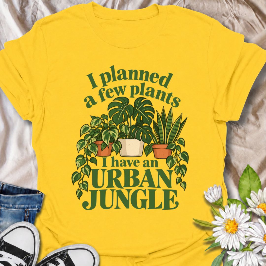 A funny plant T-shirt for anyone who started with a few houseplants and somehow ended up living in an indoor jungle. The phrase “I Planned a Few Plants. I Have an Urban Jungle.” captures the familiar reality of plant collecting with light, relatable humor. Featuring monstera, pothos, and snake plants, this design is perfect for plant parents, houseplant collectors, and indoor gardeners. It makes a great gift for anyone whose shelves, windowsills, and corners have slowly disappeared behind greenery. Perfect 