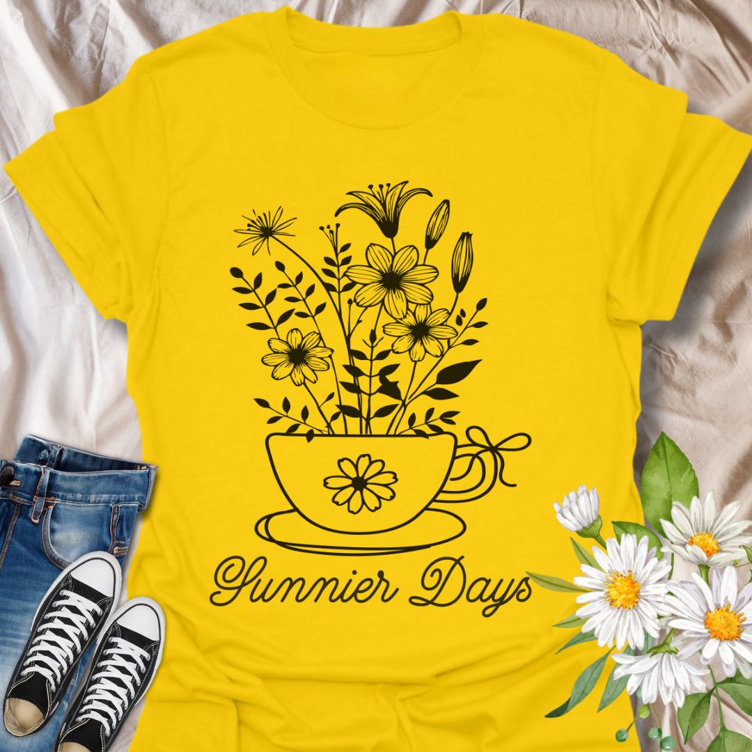 Charming floral t-shirt featuring hand-drawn white flowers blooming from a teacup with the words “Sunnier Days.” A cozy, uplifting design for flower lovers, tea drinkers, and anyone who embraces the simple joys of life. Great gift for gardeners and sunny souls.