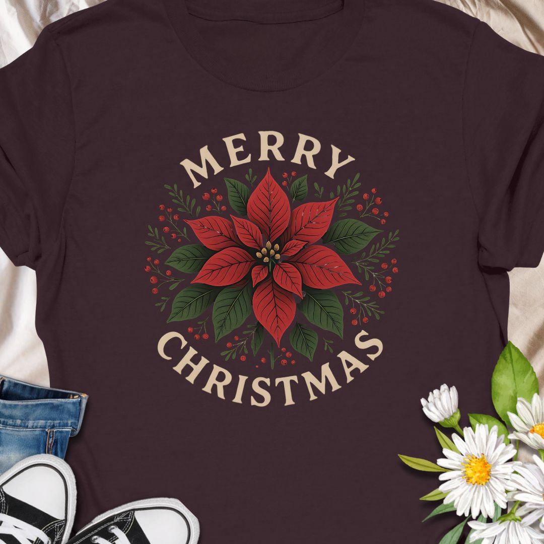 Botanical tee that carries a quietly festive spirit — a poinsettia framed by warm "Merry Christmas" lettering.  Subtle vintage tones in the print give the design a homey, handmade feel that blends with cozy kitchens, neighborhood caroling, and quiet evenings by twinkling lights. Wear it while wrapping gifts, making cocoa, or hosting a laid-back family dinner