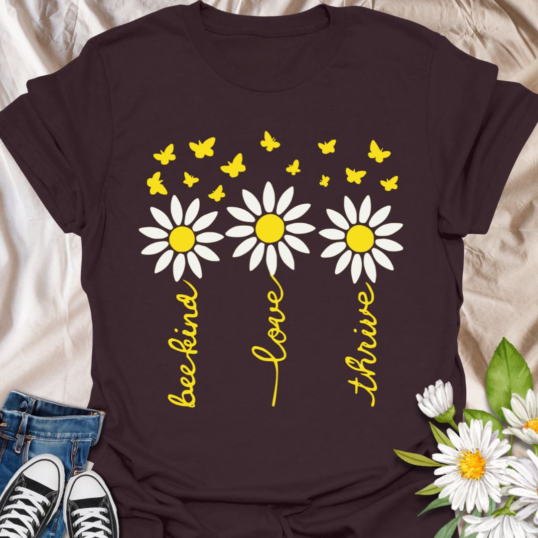Inspire positivity with this uplifting floral graphic t-shirt featuring hand-lettered words be kind, love, thrive paired with charming daisies and fluttering butterflies. A perfect gift for flower lovers, kind souls, and anyone