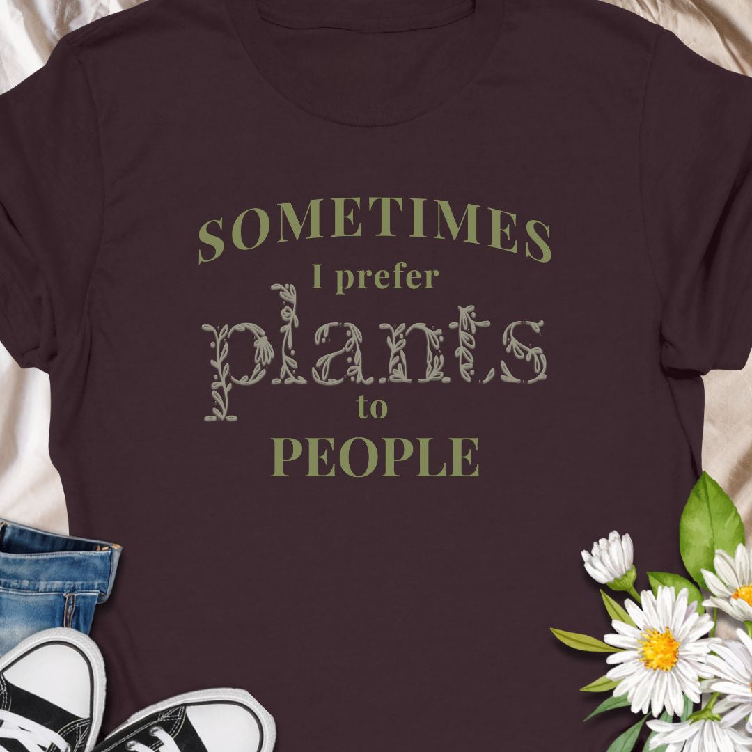 This tee speaks to the plant-lover who finds calm in soil, leaves, and slow-growing routines. The muted, nature-toned print reads “Sometimes I prefer plants to people,” a little wry and wholly relatable. Wear it while tending a crowded windowsill, carrying new finds home from the nursery, or lounging with a book as your succulents soak up afternoon light. 
