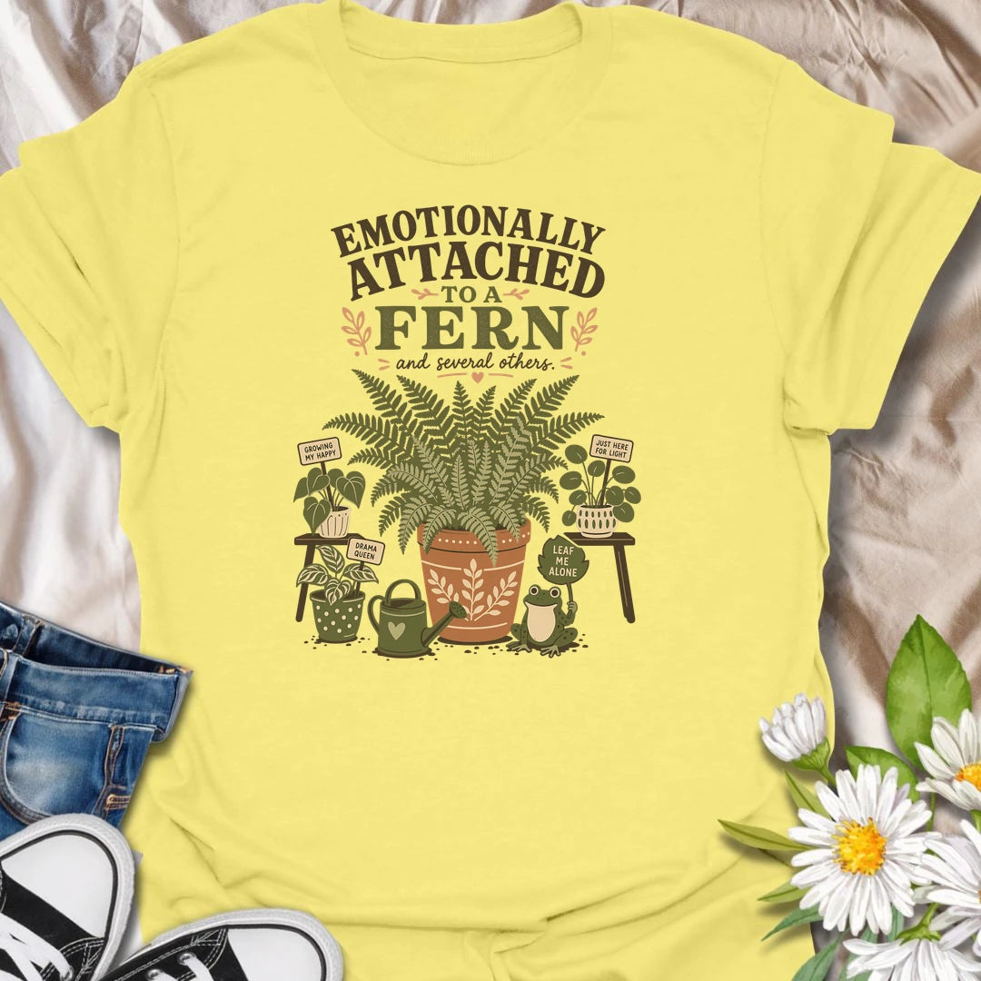 Celebrate your favorite leafy companion with this “Emotionally Attached to a Fern” T-shirt. Featuring a large decorative fern, houseplants, a watering can, and a cheerful frog, it is perfect for devoted plant parents. A charming gift for fern lovers, indoor gardeners, and botanical collectors.