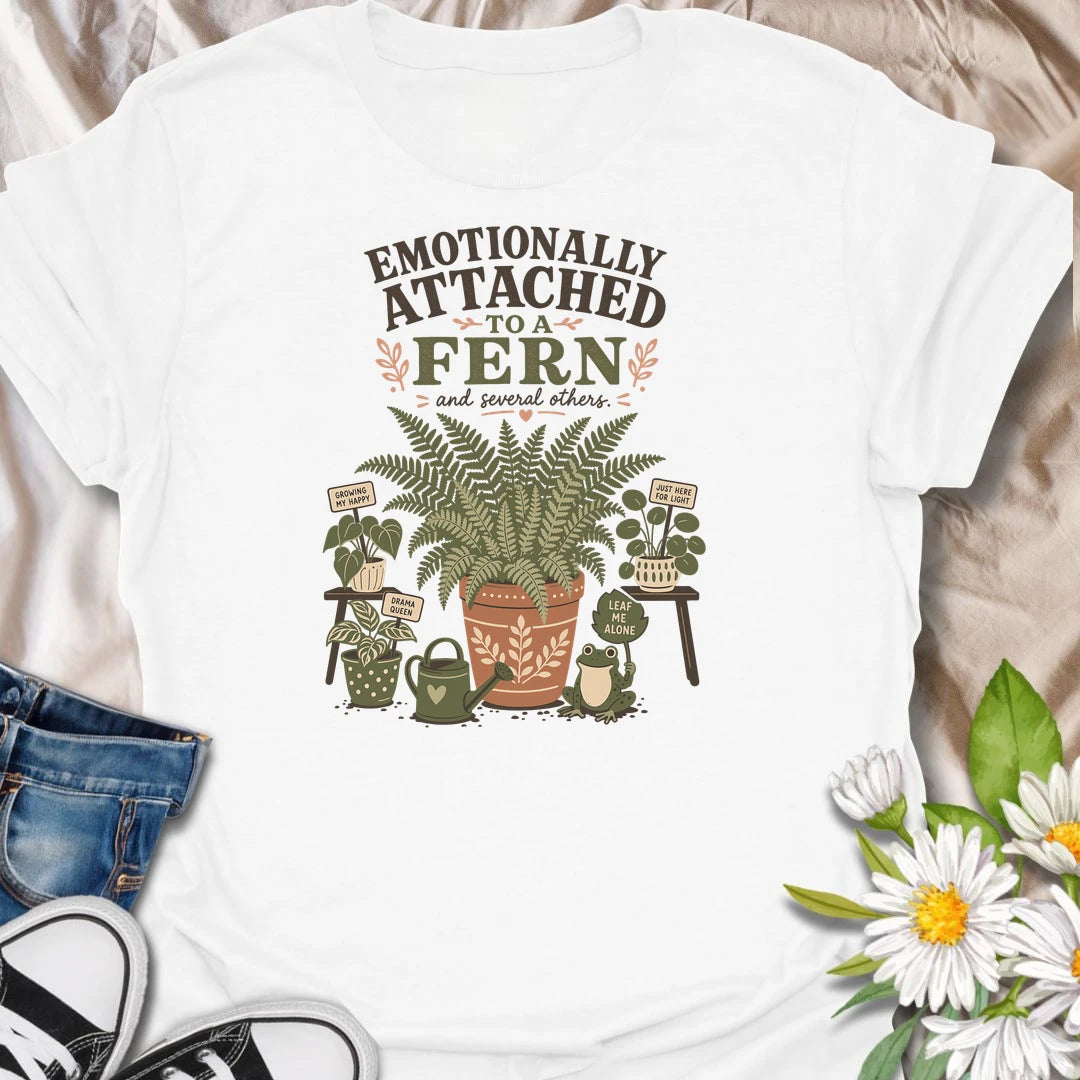Celebrate your favorite leafy companion with this “Emotionally Attached to a Fern” T-shirt. Featuring a large decorative fern, houseplants, a watering can, and a cheerful frog, it is perfect for devoted plant parents. A charming gift for fern lovers, indoor gardeners, and botanical collectors.