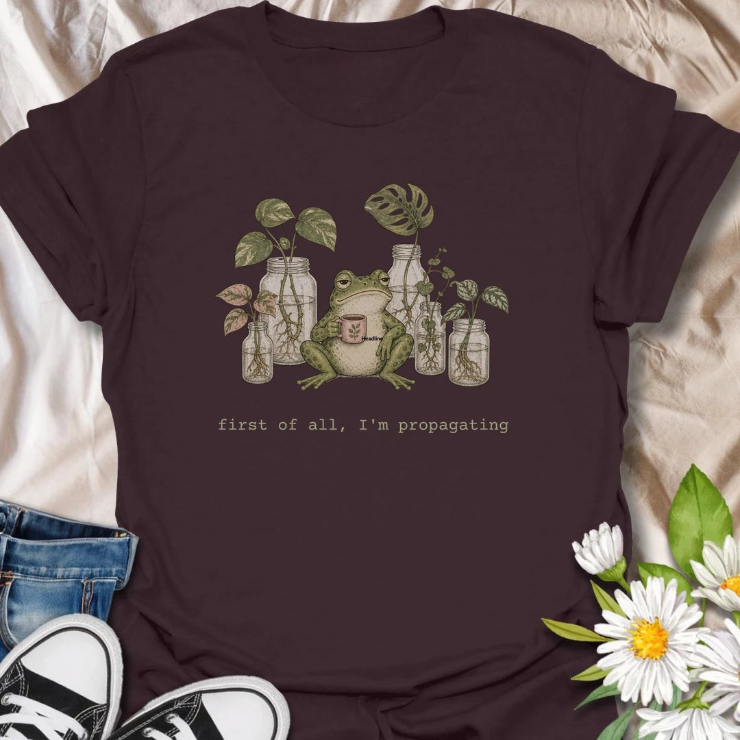 This First Of All, I’m Propagating t-shirt is perfect for plant lovers who are always snipping, rooting, and growing one more cutting. Featuring a relaxed frog holding a mug surrounded by propagation jars and trailing houseplants, this design blends cozy plant humor with a cottagecore botanical feel. Great for plant moms, plant dads, houseplant collectors, frog lovers, and anyone obsessed with propagating pothos, monstera, and indoor plants.