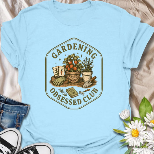Gardening Obsessed Club t-shirt for anyone who treats gardening like a hobby, lifestyle, and personality trait.
The vintage badge design features baskets, herbs, tomatoes, garden tools, and potted plants in a cozy garden club style.
It is perfect for gardeners, backyard growers, herb lovers, vegetable gardeners, and plant-loving women.
A great gift for anyone who is happiest outside with soil, seeds, and something growing.