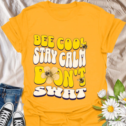 Playful bee-themed t-shirt with "Bee Cool Stay Calm Don't Swat" design. Fun gift for bee lovers, pollinator enthusiasts, and anyone who appreciates a lighthearted garden vibe. Gold