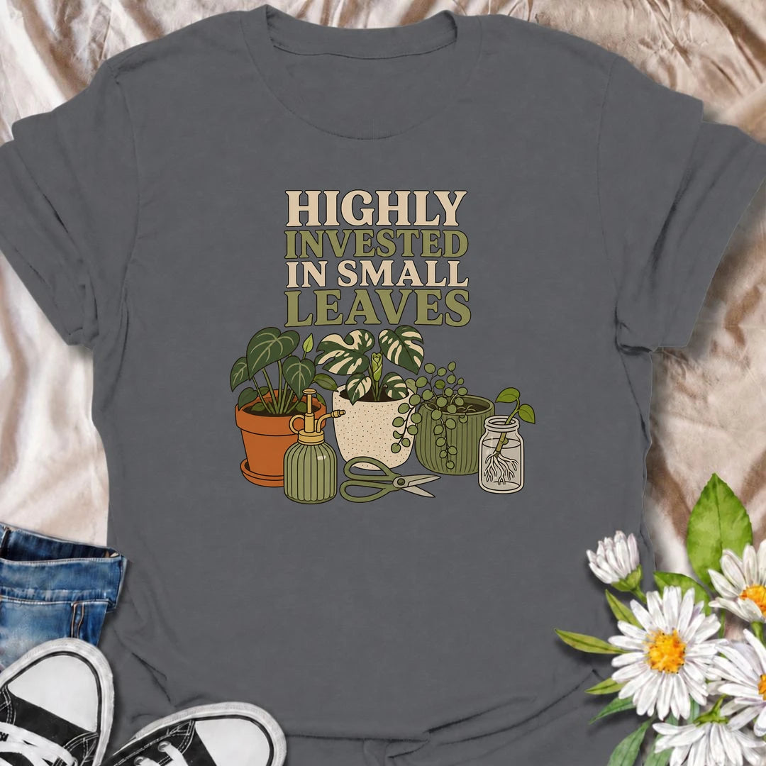 A funny houseplant T-shirt for plant lovers who are highly invested in every new leaf, cutting, and tiny bit of growth. Featuring a collection of potted plants, propagation supplies, and gardening tools, this design is perfect for dedicated plant parents and indoor gardeners. The “Highly Invested in Small Leaves” phrase captures the slightly obsessive joy of watching houseplants grow. It makes a great gift for pothos lovers, propagation fans, and anyone building their own indoor jungle. A relaxed botanical 