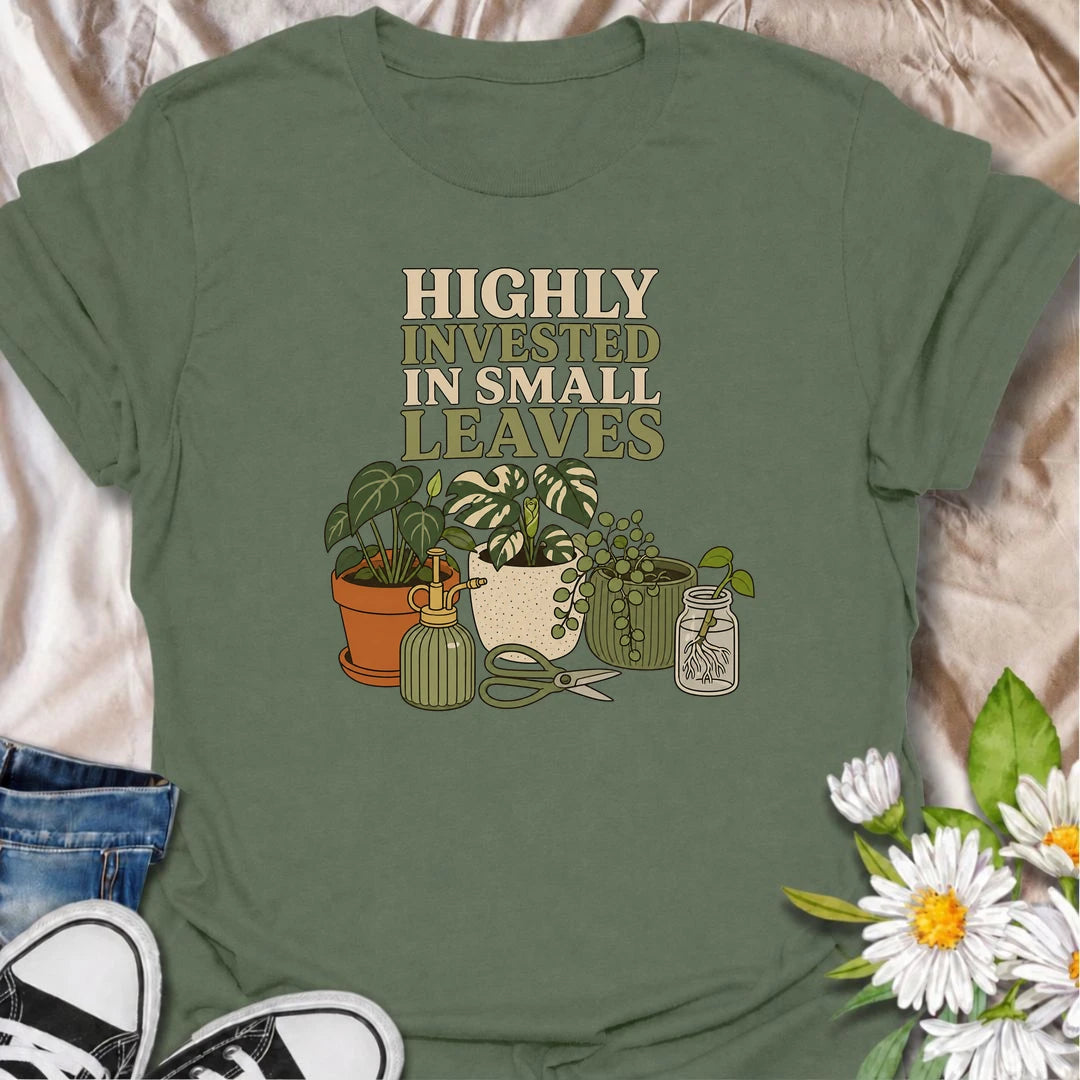 A funny houseplant T-shirt for plant lovers who are highly invested in every new leaf, cutting, and tiny bit of growth. Featuring a collection of potted plants, propagation supplies, and gardening tools, this design is perfect for dedicated plant parents and indoor gardeners. The “Highly Invested in Small Leaves” phrase captures the slightly obsessive joy of watching houseplants grow. It makes a great gift for pothos lovers, propagation fans, and anyone building their own indoor jungle. A relaxed botanical 