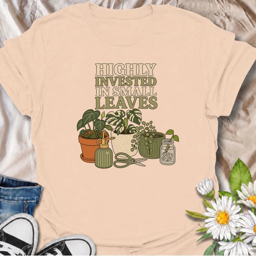 A funny houseplant T-shirt for plant lovers who are highly invested in every new leaf, cutting, and tiny bit of growth. Featuring a collection of potted plants, propagation supplies, and gardening tools, this design is perfect for dedicated plant parents and indoor gardeners. The “Highly Invested in Small Leaves” phrase captures the slightly obsessive joy of watching houseplants grow. It makes a great gift for pothos lovers, propagation fans, and anyone building their own indoor jungle. A relaxed botanical 