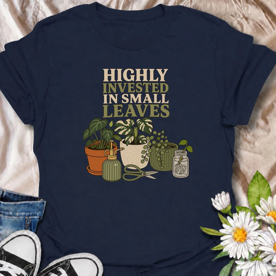 A funny houseplant T-shirt for plant lovers who are highly invested in every new leaf, cutting, and tiny bit of growth. Featuring a collection of potted plants, propagation supplies, and gardening tools, this design is perfect for dedicated plant parents and indoor gardeners. The “Highly Invested in Small Leaves” phrase captures the slightly obsessive joy of watching houseplants grow. It makes a great gift for pothos lovers, propagation fans, and anyone building their own indoor jungle. A relaxed botanical 