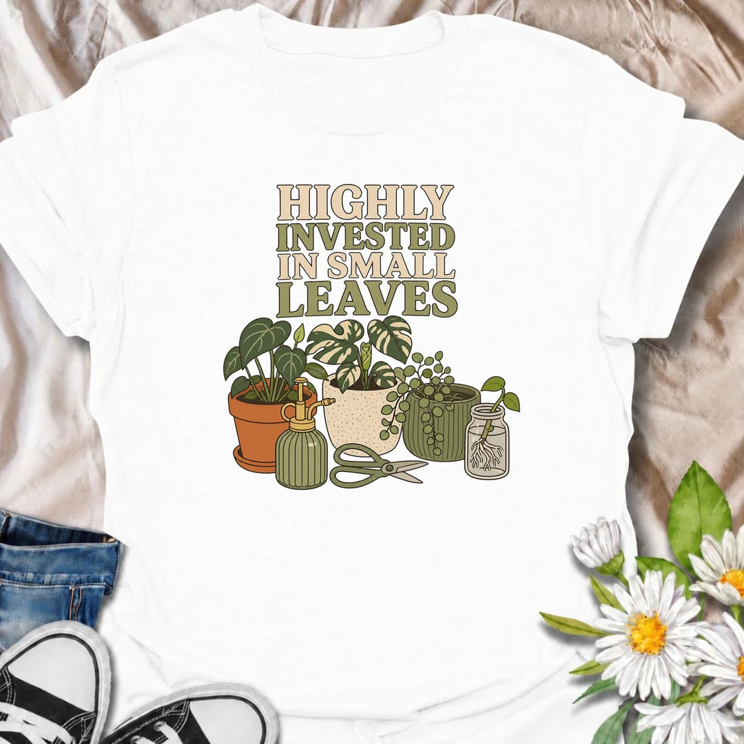 A funny houseplant T-shirt for plant lovers who are highly invested in every new leaf, cutting, and tiny bit of growth. Featuring a collection of potted plants, propagation supplies, and gardening tools, this design is perfect for dedicated plant parents and indoor gardeners. The “Highly Invested in Small Leaves” phrase captures the slightly obsessive joy of watching houseplants grow. It makes a great gift for pothos lovers, propagation fans, and anyone building their own indoor jungle. A relaxed botanical 