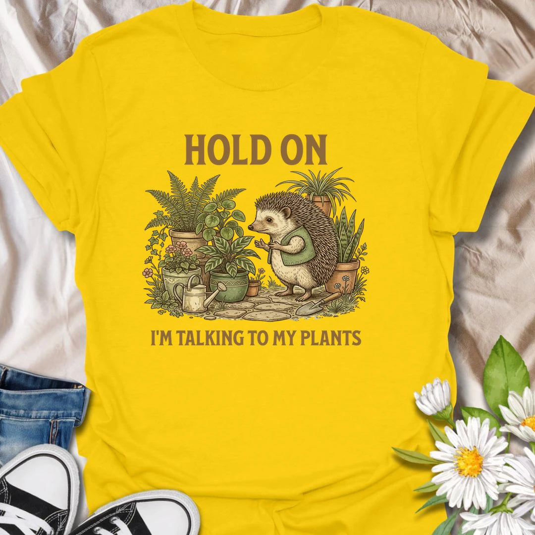 This Hold On I’m Talking To My Plants t-shirt is perfect for plant lovers who know houseplants deserve attention before people do. Featuring a cozy hedgehog chatting to potted plants in a lush botanical scene, this funny gardening design is great for plant moms, plant dads, houseplant collectors, indoor gardeners, nature lovers, and anyone who happily talks to their plants.