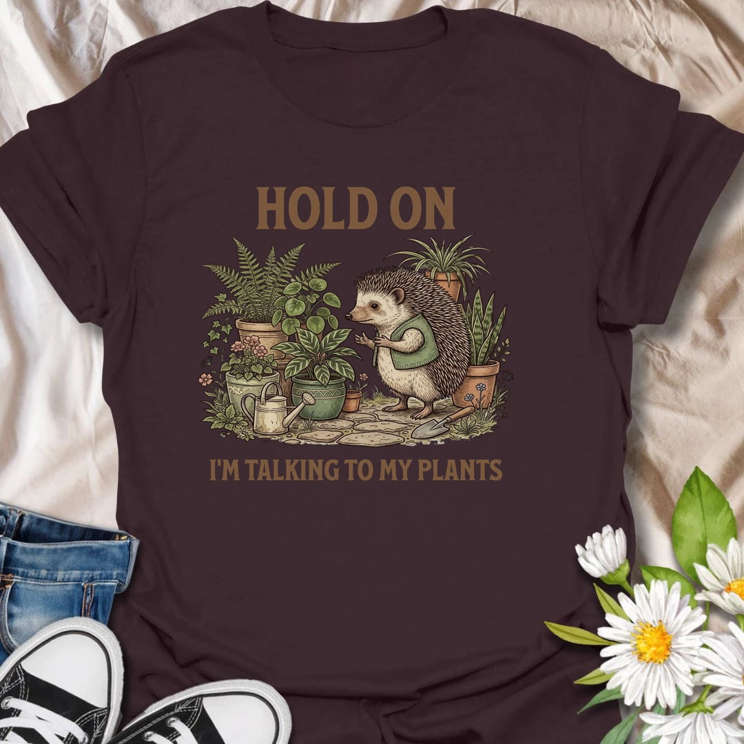 This Hold On I’m Talking To My Plants t-shirt is perfect for plant lovers who know houseplants deserve attention before people do. Featuring a cozy hedgehog chatting to potted plants in a lush botanical scene, this funny gardening design is great for plant moms, plant dads, houseplant collectors, indoor gardeners, nature lovers, and anyone who happily talks to their plants.
