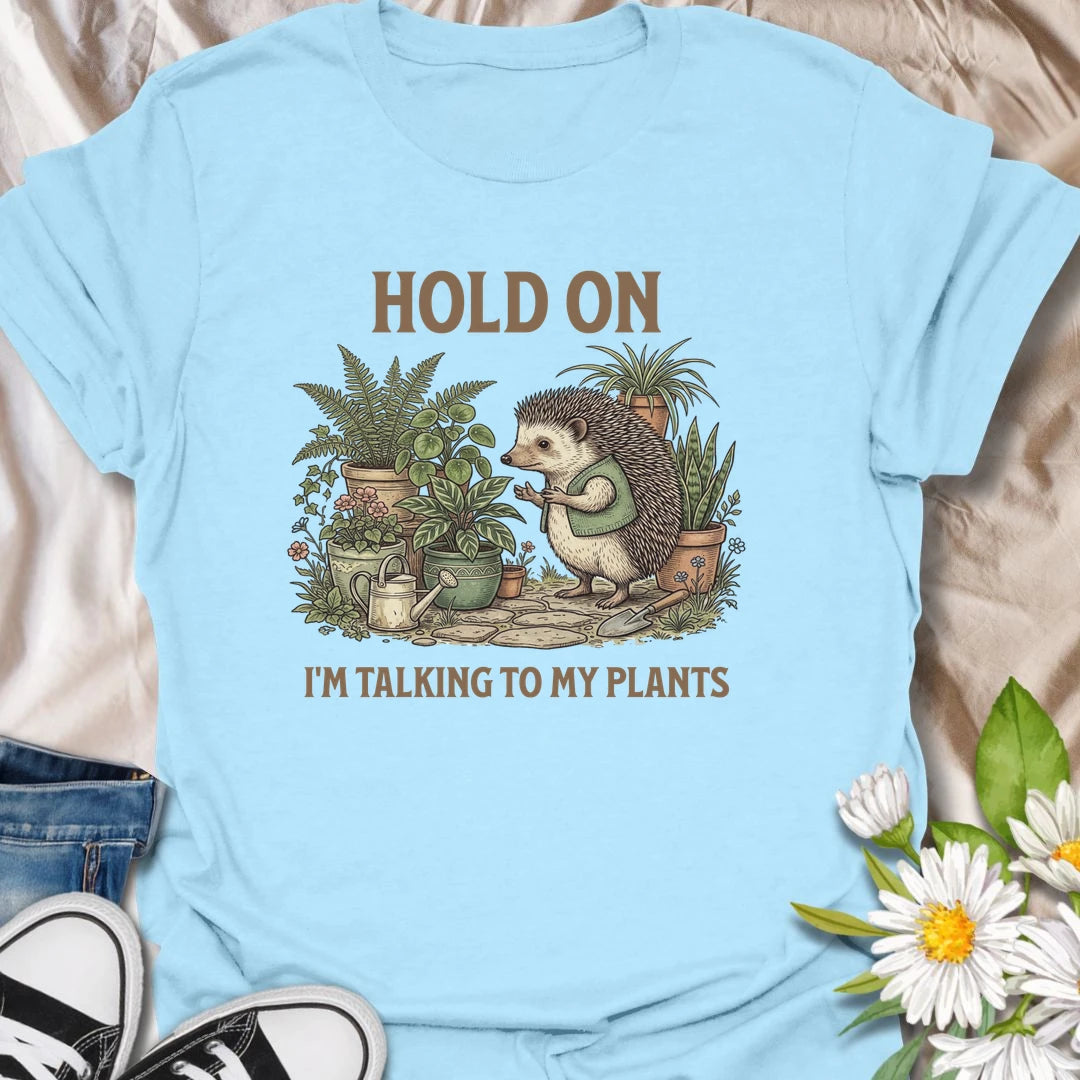 This Hold On I’m Talking To My Plants t-shirt is perfect for plant lovers who know houseplants deserve attention before people do. Featuring a cozy hedgehog chatting to potted plants in a lush botanical scene, this funny gardening design is great for plant moms, plant dads, houseplant collectors, indoor gardeners, nature lovers, and anyone who happily talks to their plants.