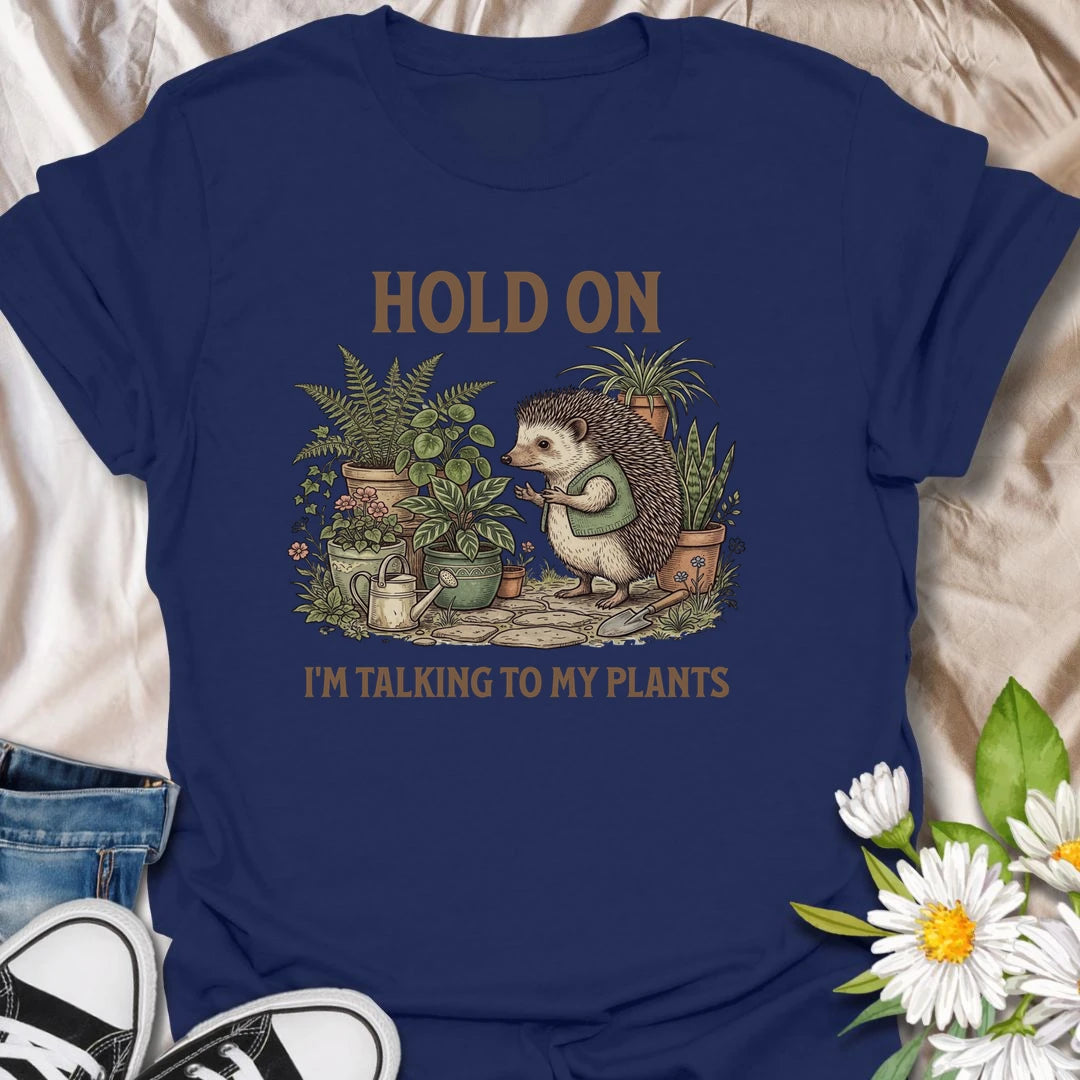 This Hold On I’m Talking To My Plants t-shirt is perfect for plant lovers who know houseplants deserve attention before people do. Featuring a cozy hedgehog chatting to potted plants in a lush botanical scene, this funny gardening design is great for plant moms, plant dads, houseplant collectors, indoor gardeners, nature lovers, and anyone who happily talks to their plants.