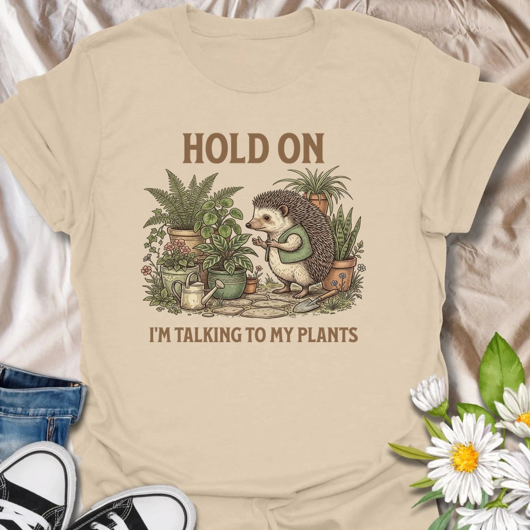 This Hold On I’m Talking To My Plants t-shirt is perfect for plant lovers who know houseplants deserve attention before people do. Featuring a cozy hedgehog chatting to potted plants in a lush botanical scene, this funny gardening design is great for plant moms, plant dads, houseplant collectors, indoor gardeners, nature lovers, and anyone who happily talks to their plants.
