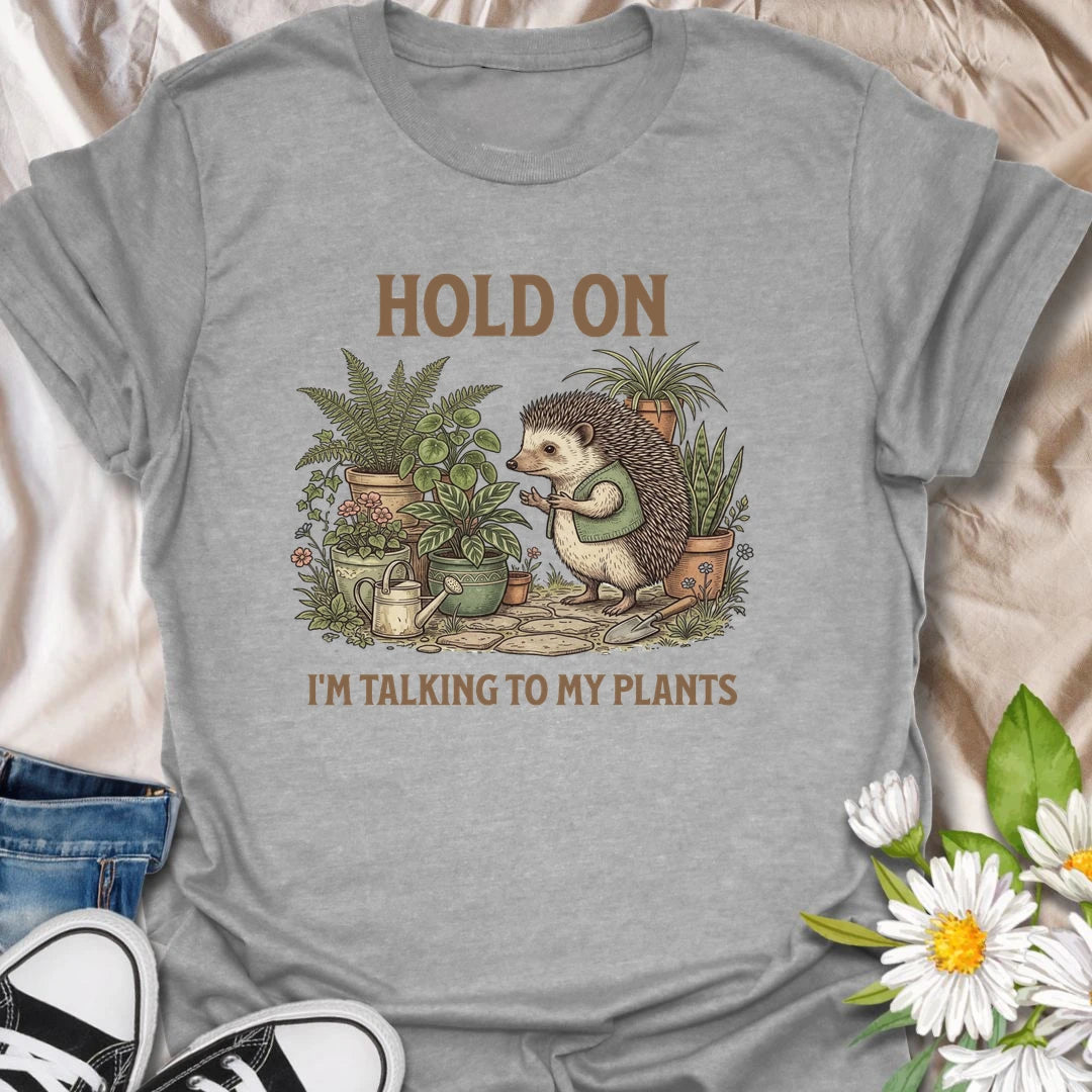 This Hold On I’m Talking To My Plants t-shirt is perfect for plant lovers who know houseplants deserve attention before people do. Featuring a cozy hedgehog chatting to potted plants in a lush botanical scene, this funny gardening design is great for plant moms, plant dads, houseplant collectors, indoor gardeners, nature lovers, and anyone who happily talks to their plants.