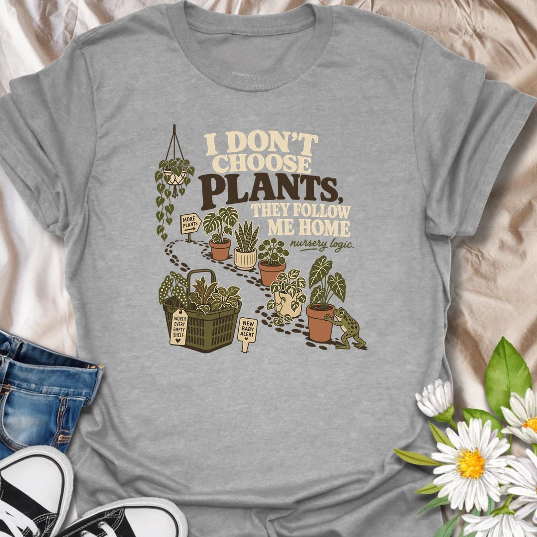 A funny houseplant T-shirt for anyone who never intends to buy another plant but somehow does. The design features a trail of potted plants, a full shopping basket, and a playful frog helping another plant come home. A perfect gift for nursery shoppers, plant collectors, and proud plant parents.
