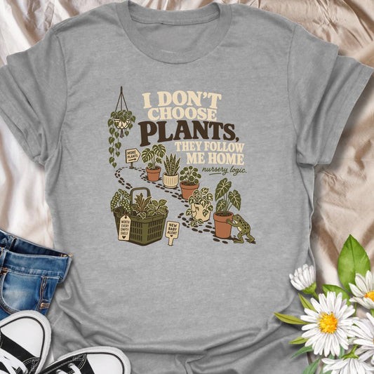 A funny houseplant T-shirt for anyone who never intends to buy another plant but somehow does. The design features a trail of potted plants, a full shopping basket, and a playful frog helping another plant come home. A perfect gift for nursery shoppers, plant collectors, and proud plant parents.