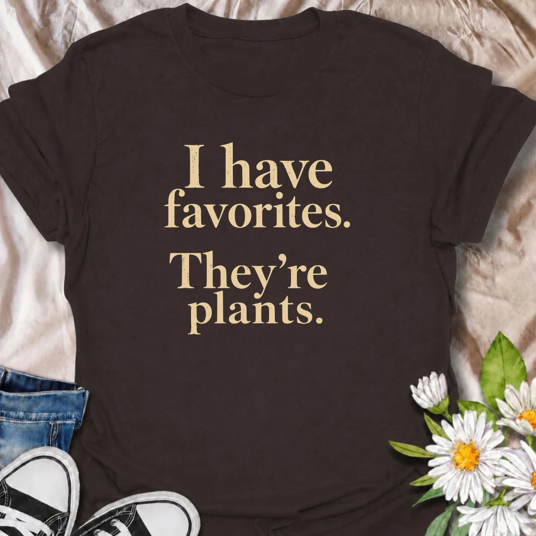 A funny plant T-shirt for anyone who definitely has favorites—and they happen to be plants. The phrase “I Have Favorites. They’re Plants.” delivers simple, dry humor that houseplant lovers and plant collectors will instantly relate to. Perfect for plant parents, indoor gardeners, and anyone who would happily choose a nursery trip over most social plans. The clean typography makes it easy to wear while still feeling niche and personality-driven. A great gift for pothos fans, plant ladies, and anyone building